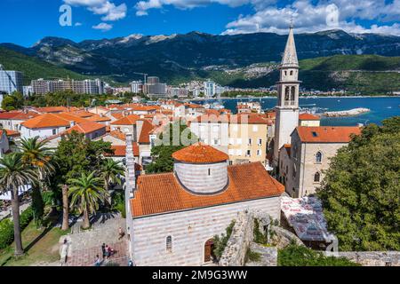 Erhöhte Aussicht auf die Kirche der Heiligen Dreifaltigkeit, mit Glockenturm der Kirche St. Ivan auf der rechten Seite, in der Altstadt von Budva an der Adriaküste von Montenegro Stockfoto