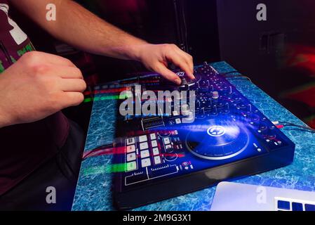 Auf einer Party in einem Nachtklub spielt und mischt DJ Musik auf einem modernen Musikcontroller Stockfoto