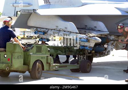 010507-F-2022C-004. [Complete] Scene Caption: Private First Class Samual Gregorey, USMC, fährt das MHU-83 C/E Munitions Loading System. Andere Mitglieder der 533. Marine Strike Fighter Squadron (VMFA) bereiten sich darauf vor, drei 305 kg schwere Mk 81-Übungsbomben mit Mk 15-Bombenverzögerungsrippen während des TANDEM-SCHUBS auf die F/A-18D Hornet zu laden. Die F-18 trägt außerdem sechs BDU-48/B 10 kg schwere Übungsbomben auf dem A/A37B-6E Multi Ejector Rack. TANDEM-SCHUBKRAFT ist eine kombinierte Militärübung der USA, Australiens und Kanadas. Diese halbjährliche Übung findet in der Nähe von Sho statt Stockfoto