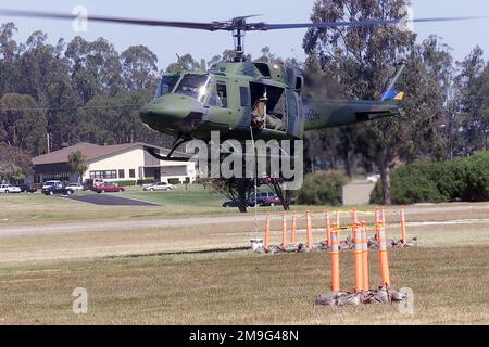 010508-F-7685H-019. [Complete] Scene Caption: Führung der UH-1N Iroquois durch den Piloten, Scanner First Lieutenant Matt Cotreras, USAF, 37. Helicopter Flight, 90. Space Wing, F.E. Der Luftwaffenstützpunkt Warren, Wyoming, leitet die Bewegungen, um einen Eimer Wasser aus dem Hubschrauber durch eines der Hindernisse auf der Strecke zu führen. Der Helicopter Hover Competition Course wird mit einer dreiköpfigen Crew, einem Piloten und einem Kopiloten mit einem Flugingenieur oder einem zusätzlichen Piloten als Scanner geflogen. Sowohl der Pilot als auch der Kopilot fliegen den gesamten Kurs, und die erreichten Punktzahlen werden gemittelt, um die Punktzahl des Teams zu bestimmen. WÄCHTER CH Stockfoto