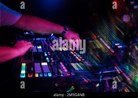 Spielt DJ-Musik auf einem professionellen Mixerboard in einem Nachtclub Stockfoto