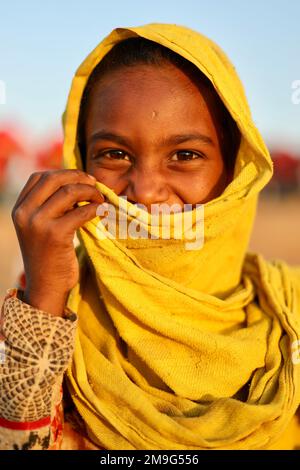 Pushkar, Rajasthan, Indien - Nov. 9 2022: Porträt eines sehr jungen Rajasthani oder Marwadi süßen Mädchens in gelbem Kleid. Stockfoto