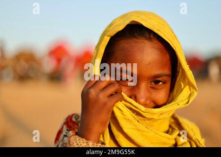 Pushkar, Rajasthan, Indien - Nov. 9 2022: Porträt eines sehr jungen Rajasthani oder Marwadi süßen Mädchens in gelbem Kleid. Stockfoto