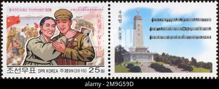 2010 Nordkorea-Stempel. 60. Jahre chinesische Hilfe im Koreakrieg. Chinesischer Soldat mit koreanischem Zivilisten Stockfoto