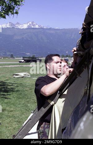 US Air Force STAFF Sergeant Ray Angel und US Air Force SENIOR AIRMAN Stephanie Branscomb beide von der 31. Medical Group, Aviano Air Base, Italien, Befestigen Sie das Innenfutter an einem temperamentvollen Zelt, das die 31. Med Group zusammen mit Mitgliedern der New Jersey Army National Guard errichtet hat, um die reale Krankenrufbehandlung von Militärmitgliedern zu nutzen, die die multinationale Trainingsübung VENETO RESCUE 01 in Nordost-Italien und Slowenien unterstützen. Veneto Rescue ist eine Übung, die bei der Ausbildung militärischer Einheiten zur Durchführung der sicheren Evakuierung nicht-kombattanter Zivilisten und anderer ausgewiesener Evakuierungen aus einem c hilft Stockfoto