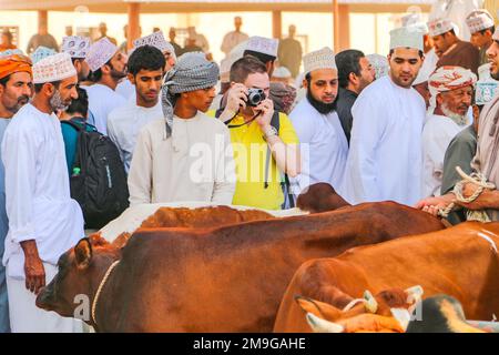 Einfacher Tourist aus dem Westen, der Fotos auf dem traditionellen Ziegenmarkt in Nizwa, Sultanat Oman, Arabische Halbinsel, Asien macht Stockfoto