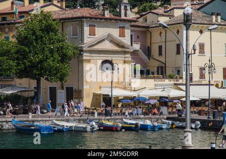 Menschen, die sich in den Bars am Ufer in Malcesine, Gardasee, Norditalien entspannen Stockfoto