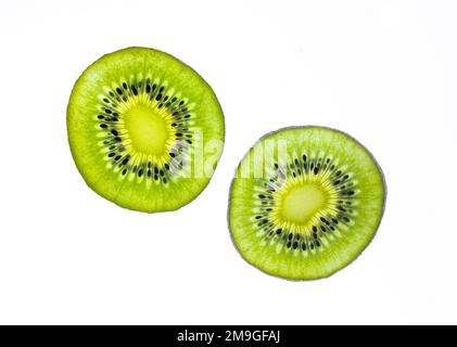 Ein Paar üppige Kiwi-Fruchtscheiben, fotografiert vor weißem Hintergrund Stockfoto