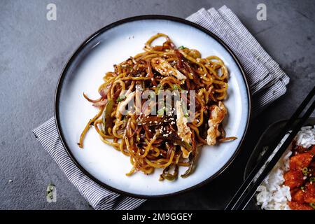 Hähnchen Lo Mein Nudeln garniert mit gerösteten Sesamsamen und Frühlingszwiebeln Stockfoto