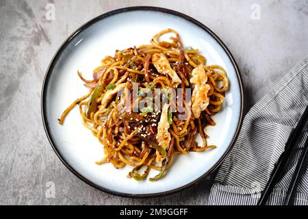 Hähnchen Lo Mein Nudeln garniert mit gerösteten Sesamsamen und Frühlingszwiebeln Stockfoto