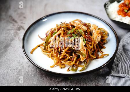 Hähnchen Lo Mein Nudeln garniert mit gerösteten Sesamsamen und Frühlingszwiebeln Stockfoto