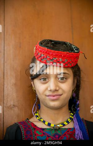 Porträt eines Kalash-Mädchens mit farbenfroher traditioneller Kopfbedeckung, Bumburet Valley, Pakistan Stockfoto