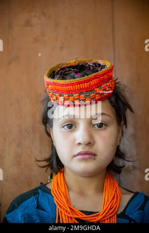 Porträt eines Kalash-Mädchens mit farbenfroher traditioneller Kopfbedeckung, Bumburet Valley, Pakistan Stockfoto