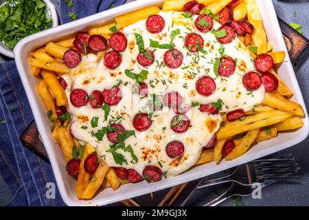 Pizzaladung pommes frites. Hausgemachte Pepperoni und Käse Pizza Pommes frites. Im Ofen gebackene pommes frites, Kartoffelauflauf mit Käse, Salami und Salami Stockfoto