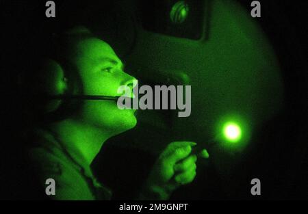 011006-F-1644L-033. [Complete] Scene Caption: Aus der Sicht eines Nachtsichtgeräts inspiziert ein Kopilot des Air Force C-17 Globemaster III eine Schalttafel im Cockpit, während er unterwegs ist, um das Tri-Wall Aerial Delivery System (TRIADEN) zu liefern, das mit humanitären Tagesrationen (HDR's) beladen ist. Air Force C-17s lieferte HDRs zur Unterstützung DER DAUERHAFTEN FREIHEIT von Deutschland an afghanische Flüchtlinge, die sich innerhalb der Grenzen Afghanistans versammelt haben. Die C-17s enthielt über 35.000 HDRs, verpackt in 84 TRIADEN-Boxen mit einer Größe von 80 Zoll und einem Quadrat von 48 x 48 Zoll, jeweils mit 420 HDRs gefüllt. Die HDRs wurden in geliefert Stockfoto