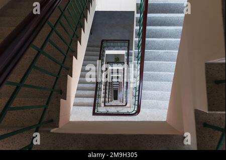 Blick von oben auf eine rechteckige, altmodische Treppe mit endlosem Muster auf dem Gebäude Stockfoto