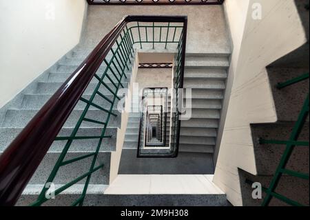 Blick von oben auf die rechteckige, altmodische Treppe, endloses Muster auf dem Hotelgebäude Stockfoto