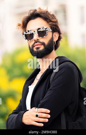 Ein Mann mit modischer Sonnenbrille, der in die Kamera schaut Stockfoto