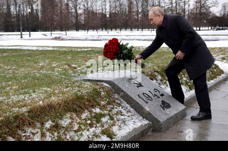 St. Petersburg, Russland. 18. Januar 2023. Der russische Präsident Wladimir Putin legt Blumen auf ein Massengrab an dem Denkmal des Mutterlandes, das anlässlich des 80. Jahrestages der Belagerung von Leningrad im Zweiten Weltkrieg auf dem Piskaryovskoye Memorial Cemetery in St. stattfindet Petersburg, Russland. Kredit: Mikhail Klimentyev/Kremlin Pool/Alamy Live News Stockfoto