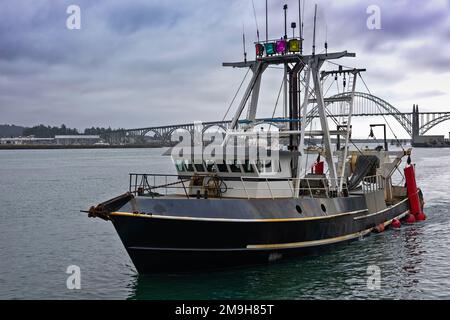 Fischerboot mit Brücke im Hintergrund, Newport, Oregon, USA Stockfoto