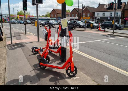 Slough, Großbritannien. 10. Juni 2022. Das von der Firma Neuron Mobility betriebene Testmietprogramm für E-Scooter in Slough wurde um weitere zwei Jahre verlängert. Die orangefarbenen Roller sind zwar beliebt, aber im Allgemeinen wurden E-Roller kritisiert, da einige Benutzer auf Gehwegen und Straßen mit ihnen zu Unfällen fahren. Es wurde auch berichtet, dass einige Konsumenten unter dem Einfluss von Alkohol stehen, wenn sie sie verwenden, insbesondere nachts. Kredit: Maureen McLean/Alamy Stockfoto