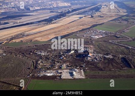 Erkelenz, Deutschland. 18. Januar 2023. Bagger zerstören die letzten Häuser des Dorfes Lützerath. Nach der Räumung der Klimaaktivisten soll das Dorf nun Platz für den Braunkohlebergbau machen. Kredit: Federico Gambarini/dpa/Alamy Live News Stockfoto