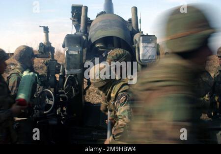 MITGLIEDER DES US Marine Corps (USMC), die dem 3. Bataillon zugeteilt sind, 12. Marines, Tango Battery, gehen in Sicherheit, während sie ihren M198 gezogenen Howitzer auf dem Artilleriebereich auf dem Hijudai Training Grounds, Oita, Japan, abfeuern. Basis: Camp Hijudai Staat: Oita Land: Japan (JPN) Stockfoto