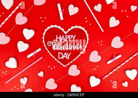 Valentinstag flach mit Herz mit Text „Happy Valentine's Day“ und Herzschmuck auf rotem Hintergrund Stockfoto