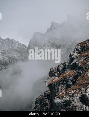 Ein vertikaler Schuss von schwimmenden Wolken über den Bergen in Österreich in der Nähe der Hochalpenstraße Grossglockner Stockfoto