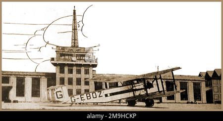 1930 verbesserte Fotografie des Hauptterminals und Kontrollturms am Croydon Aerodrome (Flughafen), London. Mit einem biplanen G-EBOZ in Bereitschaft. Stockfoto