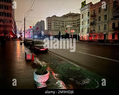 Kiew, Ukraine - 14. Januar 2023: Stromausfall in den ukrainischen Straßen ohne Straßenbeleuchtung reflektiert nur die Farbe der Ampel und der Autolichter Stockfoto