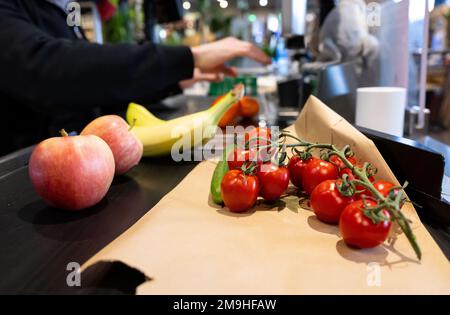 Neubiberg, Deutschland. 18. Januar 2023. Lebensmittel liegen auf dem Förderband an der Kasse in einem Supermarkt. Angesichts der hohen Inflation erwarten die Verbraucherverbände einen weiteren Anstieg der Lebensmittelpreise. Kredit: Sven Hoppe/dpa/Alamy Live News Stockfoto