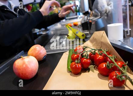 Neubiberg, Deutschland. 18. Januar 2023. Lebensmittel liegen auf dem Förderband an der Kasse in einem Supermarkt. Angesichts der hohen Inflation erwarten die Verbraucherverbände einen weiteren Anstieg der Lebensmittelpreise. Kredit: Sven Hoppe/dpa/Alamy Live News Stockfoto