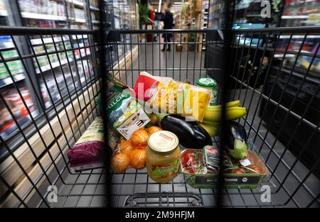 Neubiberg, Deutschland. 18. Januar 2023. Verschiedene Lebensmittel liegen in einem Einkaufswagen in einem Supermarkt. Angesichts der hohen Inflation erwarten die Verbraucherverbände einen weiteren Anstieg der Lebensmittelpreise. Kredit: Sven Hoppe/dpa/Alamy Live News Stockfoto