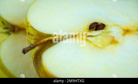 Apfelherz wird halbiert, die Samen sind sichtbar, Makrofoto. Stockfoto