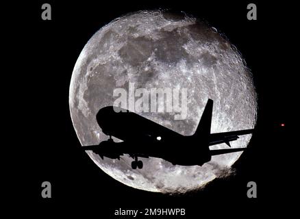 Jet in Silhouette vor dem Mond Stockfoto