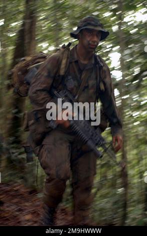 Der US Marine Corps (USMC) Corporal (CPL) Charlie Dixon, der mit dem Bodenkampfelement durch den Dschungel von Brunei trampelt, während der Landung Force Cooperation Float Readiness and Training (CARAT), erwägt die bevorstehende Übung. Land: Brunei Darussalam (BRN) Stockfoto