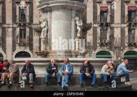 Geselliges Treffen alter Männer in der Fontana dell' Elefante auf der Piazza Duomo, Catania, Sizilien Stockfoto