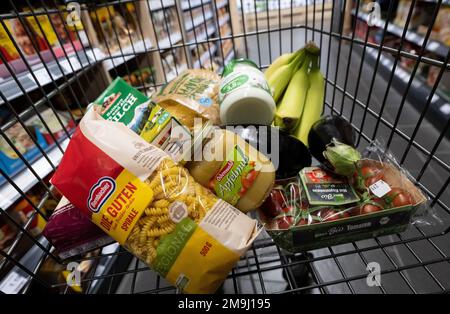 Neubiberg, Deutschland. 18. Januar 2023. Verschiedene Lebensmittel liegen in einem Einkaufswagen in einem Supermarkt. Kredit: Sven Hoppe/dpa/Alamy Live News Stockfoto