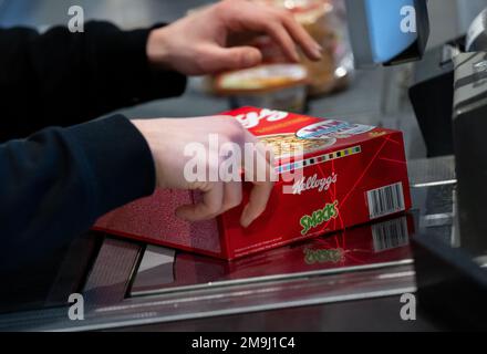 Neubiberg, Deutschland. 18. Januar 2023. Ein Kassierer scannt eine Packung Kellogg's Smacks an der Kasse in einem Supermarkt. Kredit: Sven Hoppe/dpa/Alamy Live News Stockfoto