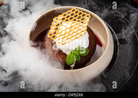 Schokoladenfondant. Dunkle Schokolade, Himbeersoße, Vanille-Eis-Dessert. Köstliche gesunde traditionelle Speisen aus der Nähe serviert zum Mittagessen in modernen Stockfoto