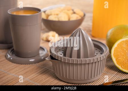 Frühstückstisch mit Saft. Bunte Tassen und Teller Stockfoto