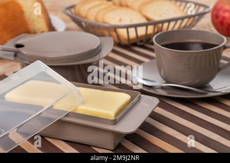 Frühstückstisch mit Saft. Bunte Tassen und Teller Stockfoto