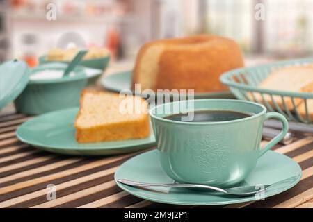 Frühstückstisch mit Saft. Bunte Tassen und Teller Stockfoto