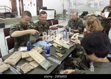 US Air Force (USAF) Brigadegeneral (BGEN) Joseph E. Kelley (Zentrum), Assistant Surgeon General of Expeditionary Operations, Science and Technology und andere angesehene Besucher essen bei BGEN Kelleys Besuch im Expeditionary Medical System (EMEDS) Krankenhauszelt in Fort Lewis, Washington (WA), 2002 während des Trainings SEAHAWK. Seahawk kombiniert aktive Dienst- und erve-Komponenten der US Air Force (USAF), der US Navy (USN), der US Coast Guard (USCG), des US Public Health Service, der Royal Canadian Armed Forces (RCAF), des Federal Bureau of Investigation (FBI) und des Federal Emergence Stockfoto