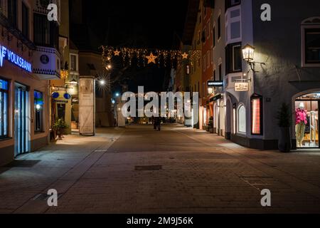 KITZBÜHEL, ÖSTERREICH - 07. JANUAR 2023: Nachtsicht auf Kitzbühel, eine kleine Alpenstadt. Gehobene Geschäfte und Cafés säumen die Straßen des mittelalterlichen Zentrums. Stockfoto