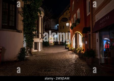 KITZBÜHEL, ÖSTERREICH - 07. JANUAR 2023: Nachtsicht auf Kitzbühel, eine kleine Alpenstadt. Gehobene Geschäfte und Cafés säumen die Straßen des mittelalterlichen Zentrums. Stockfoto