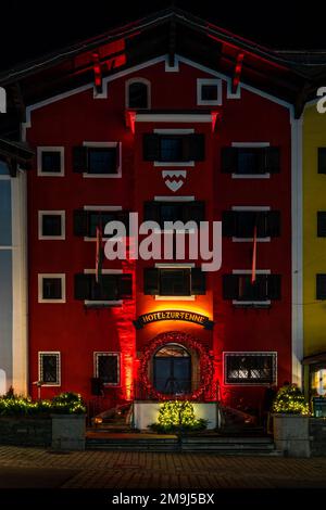 KITZBÜHEL, ÖSTERREICH - 07. JANUAR 2023: Nachtsicht auf Kitzbühel, eine kleine Alpenstadt. Gehobene Geschäfte und Cafés säumen die Straßen des mittelalterlichen Zentrums. Stockfoto