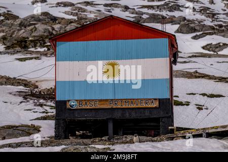 Blick auf eine riesige argentinische Flagge, die auf einer Hütte an der argentinischen Station Primavera in Cierva Cove gemalt ist, einer Bucht entlang der Westküste von Graham Land, Anta Stockfoto