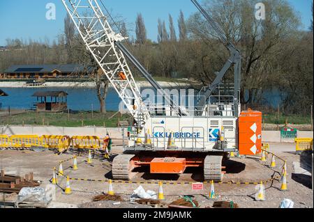 Denham, Großbritannien. 19. März 2022. HS2 Bauarbeiten für das Colne Valley Viadukt. Am ehemaligen Denham Water Ski Club neben der North Orbital Road in Denham werden Betonpiers aufgestellt. Die 700-Tonnen-Trägermaschine HS2 High Speed Rail namens Dominique ist jetzt in Betrieb und hat damit begonnen, einige der vorgegossenen Betonbrückensegmente auf das erste von 56 Pier-Segmenten für das HS2 High Speed 2 Colne Valley Viaduct zu bringen. Das Colne Valley Viaduct wird die längste Eisenbahnbrücke in Großbritannien sein. Kredit: Maureen McLean/Alamy Stockfoto